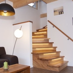 Gemütliches Interieur mit Holztreppe und stilvoller Beleuchtung im Alpenflair, Schliersee-Neuhaus. Ideal für Erholung.