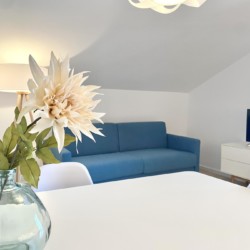 Helle, einladende FeWo in Bad Wiessee. Gemütliches Ambiente mit blauem Sofa und modernem Flair. Ideal für Urlaub am Tegernsee.