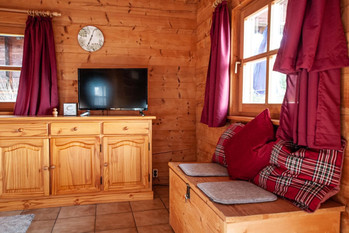 Gemütliches Holzinterieur eines Chalets in Schliersee mit Fernseher und bequemer Sitzecke. Ideal für Entspannung.