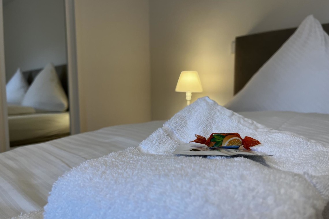 Gemütliches Schlafzimmer in Bayrischzell Ferienwohnung mit frischen Handtüchern und einladendem Ambiente.