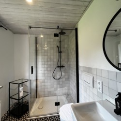 Modernes Bad in Ferienwohnung Bayrischzell: weiße Fliesen, Dusche, stilvoll. Ideal für entspannten Urlaub. Buchen auf stayfritz.com.