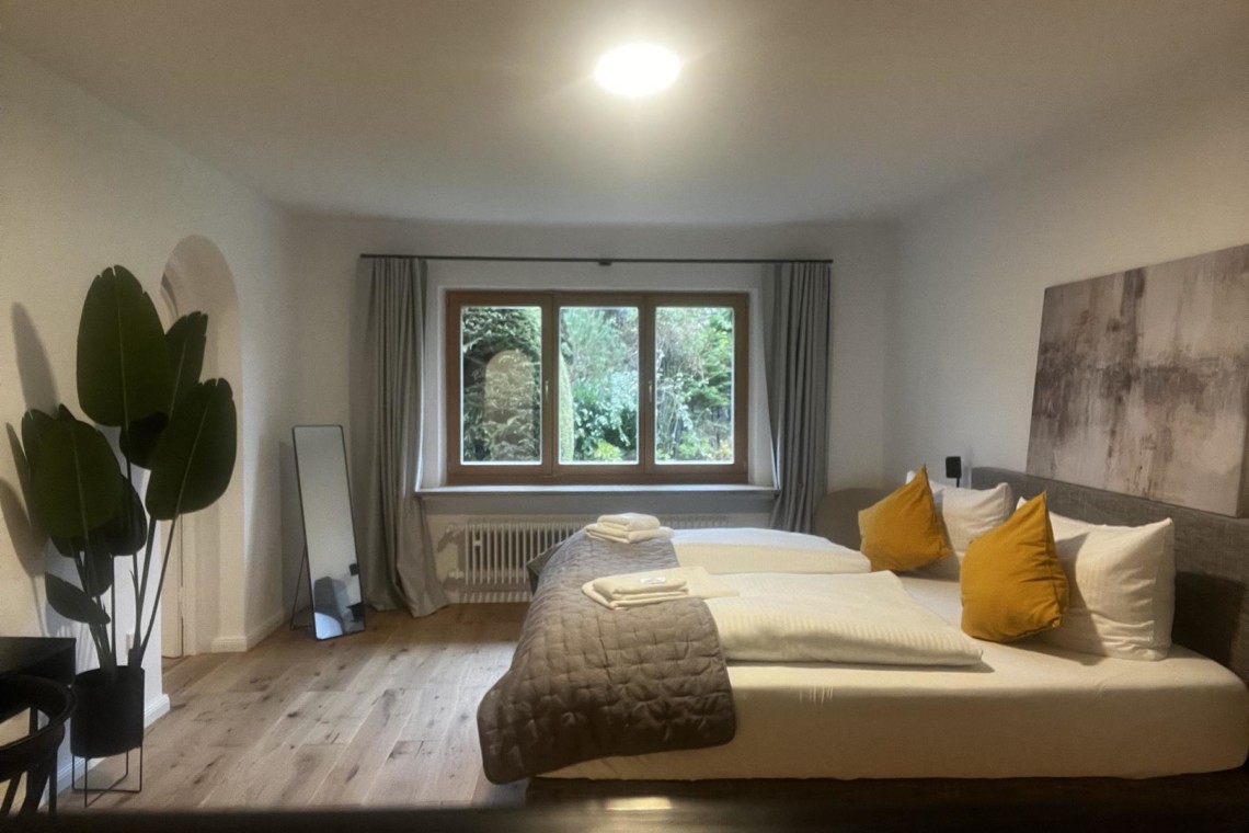Gemütliche Ferienwohnung in Rottach-Egern mit komfortablem Bett und stilvoller Einrichtung für entspannten Urlaub.