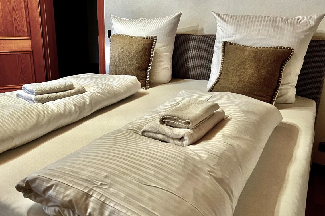 Gemütliches Schlafzimmer im Ferienhaus am Tegernsee, ideal für Ihre Erholung in Rottach-Egern. Buchen Sie Ihren Aufenthalt!