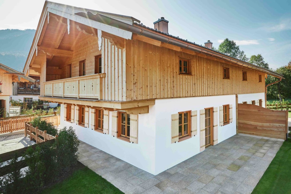 Gemütliche Doppelhaushälfte umgeben von grüner Natur im Herzen von Kreuth, ideal für einen entspannten Urlaub.