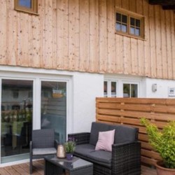Gemütliche Ferienwohnung in Fischbachau mit Holzfassade und einladender Terrasse.