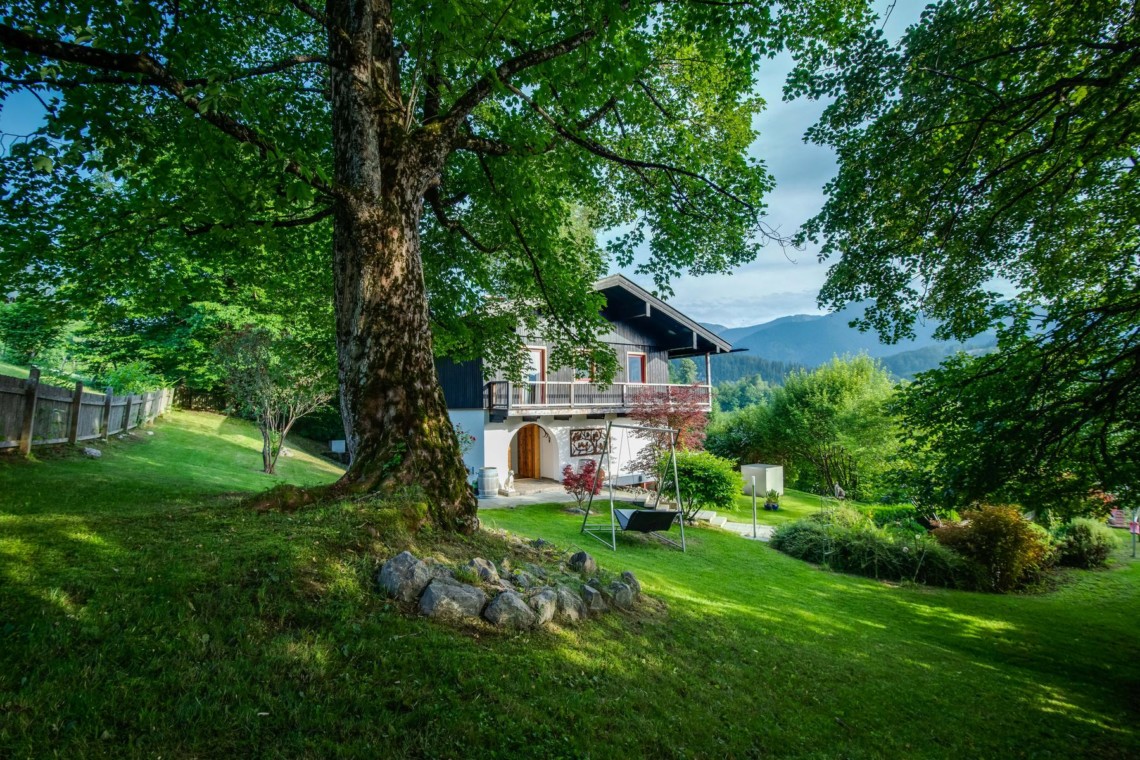 Idyllische Villa "Panoramablick" in Fischbachau, umgeben von grünen Wiesen und Bäumen, perfekt für einen entspannten Urlaub.