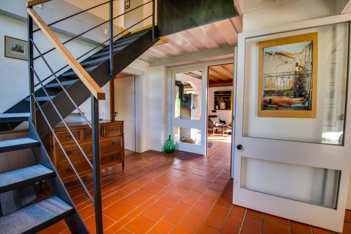 Gemütlicher Innenraum einer Ferienwohnung in Fischbachau mit Treppe und warmen Farben.