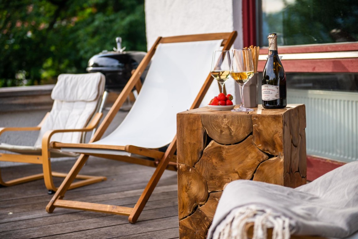 Gemütliche Terrasse mit Liegestühlen, Weingläsern und Erdbeeren, ideal für Entspannung in Fischbachau.