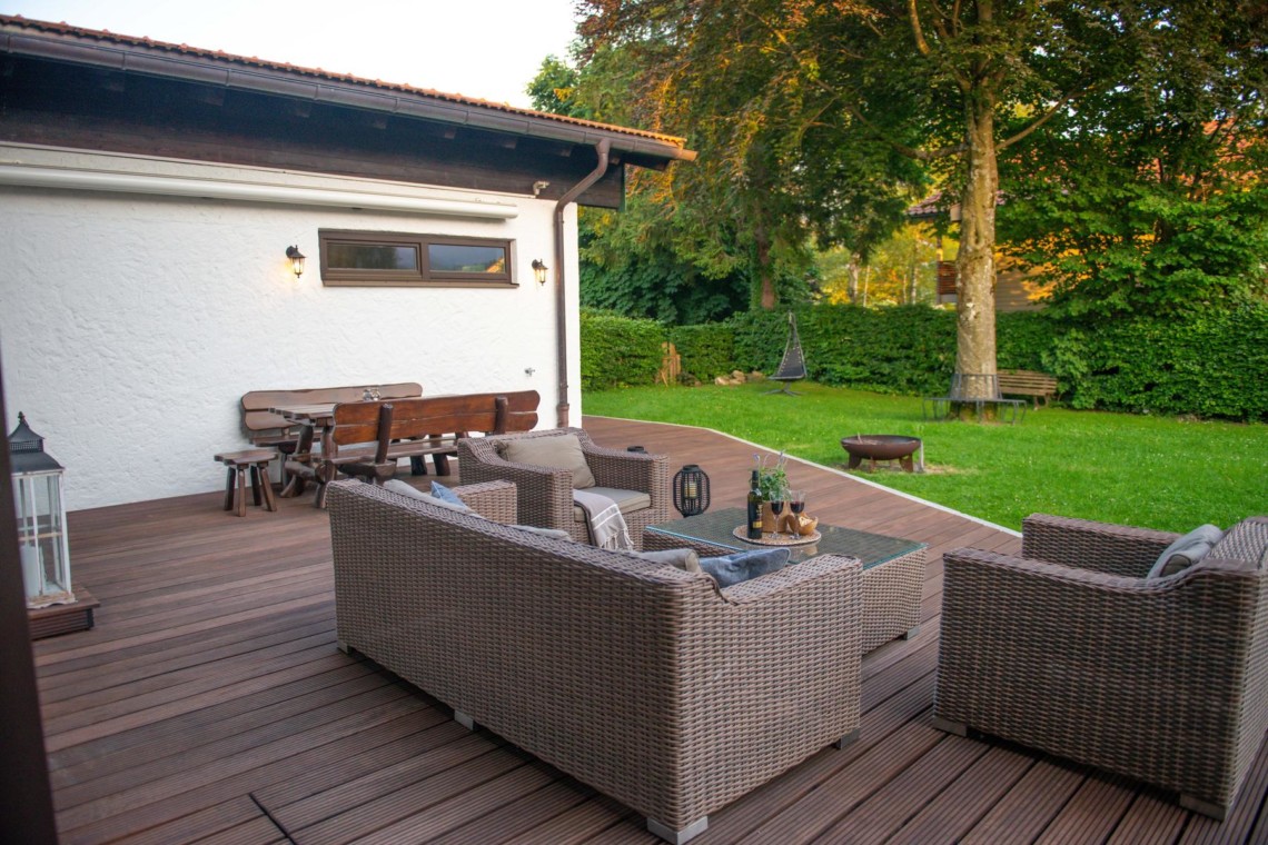 Gemütliche Terrasse mit Sitzgelegenheiten und Blick auf grünen Garten in Schliersee. Ideal für Entspannung.