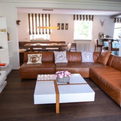 Gemütliches Wohnzimmer in Schliersee Ferienwohnung mit Ledersofa und modernem Design.
