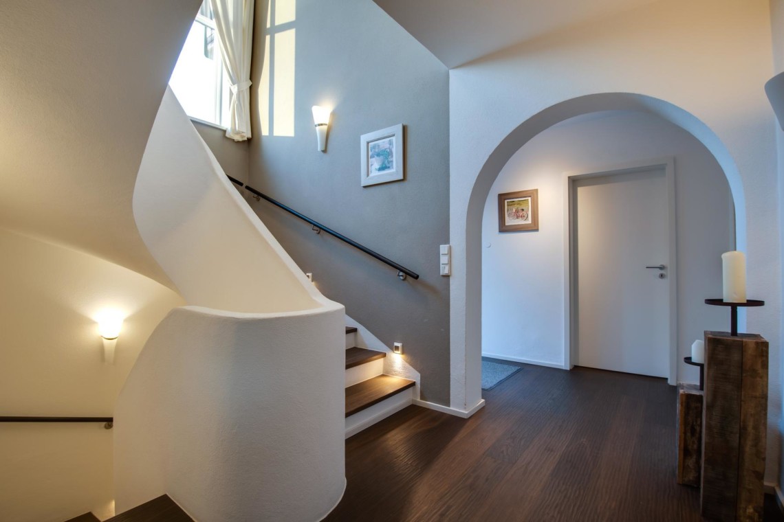 Gemütliches Apartment in Schliersee mit eleganter Wendeltreppe und warmen Lichtakzenten. Ideal für den Urlaub! #Schliersee #Ferienwohnung