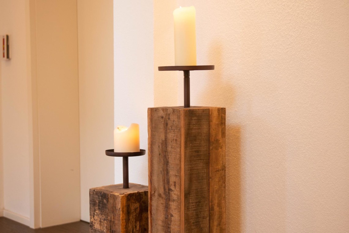Gemütliches Ambiente in Schliersee Ferienwohnung, rustikale Kerzenständer aus Holz, moderne Einrichtung.
