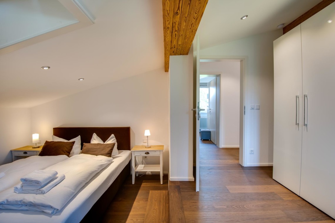 Gemütliches Schlafzimmer in Ferienwohnung "Villa Perfall17" in Schliersee, warm und einladend für einen erholsamen Aufenthalt.