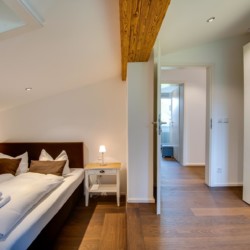 Gemütliches Schlafzimmer in Ferienwohnung "Villa Perfall17" in Schliersee, warm und einladend für einen erholsamen Aufenthalt.
