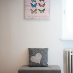 Gemütliches Interieur mit stilvollem Schmetterlingsbild und Sitzhocker – Ideal für Entspannung in Schliersee.