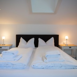 Gemütliches Doppelbett in moderner Ferienwohnung "Villa Perfall17" in Schliersee - ideal für Urlaubsaufenthalte.