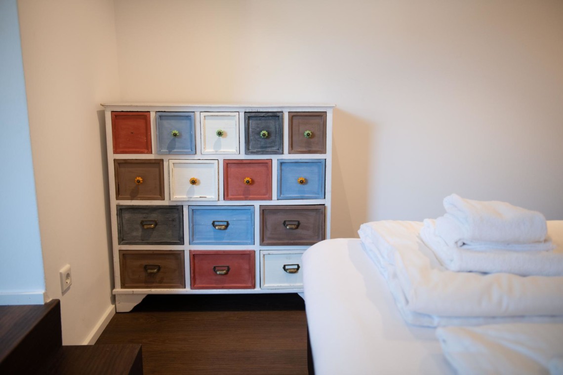 Gemütliches Zimmer in Schliersee mit buntem Schrank und frischen Handtüchern. Ideal für entspannten Urlaub.