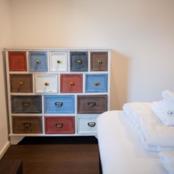 Gemütliches Zimmer in Schliersee mit buntem Schrank und frischen Handtüchern. Ideal für entspannten Urlaub.