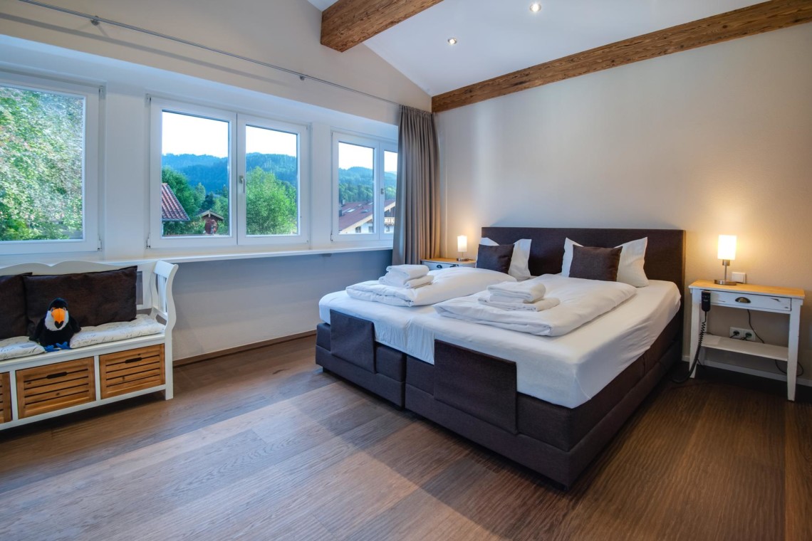 Gemütliches Schlafzimmer in Ferienwohnung "Villa Perfall17" in Schliersee, stilvoll eingerichtet für erholsamen Urlaub.