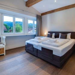 Gemütliches Schlafzimmer in Ferienwohnung "Villa Perfall17" in Schliersee, stilvoll eingerichtet für erholsamen Urlaub.