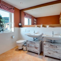 Helles, stilvolles Badezimmer in Schliersee Ferienwohnung mit Doppelwaschbecken und Bergblick.