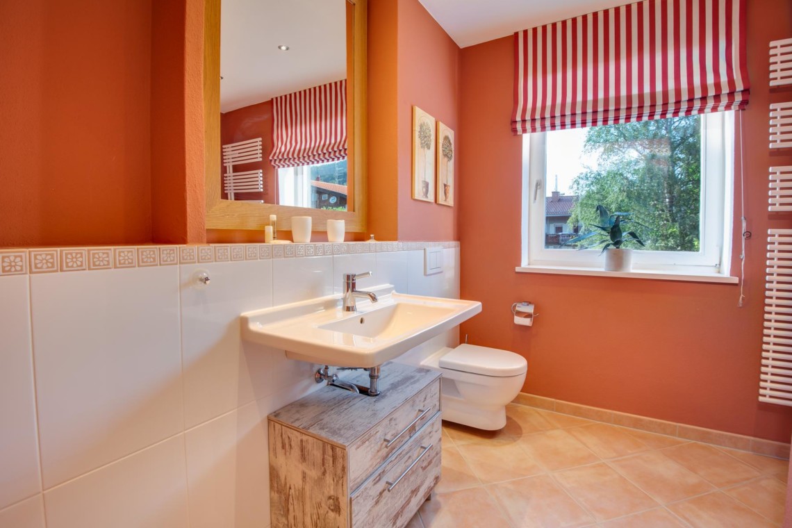 Gemütliches Badezimmer in Ferienwohnung am Schliersee, warme Farben, sauber und einladend für einen entspannten Urlaub.
