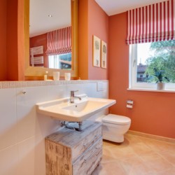 Gemütliches Badezimmer in Ferienwohnung am Schliersee, warme Farben, sauber und einladend für einen entspannten Urlaub.