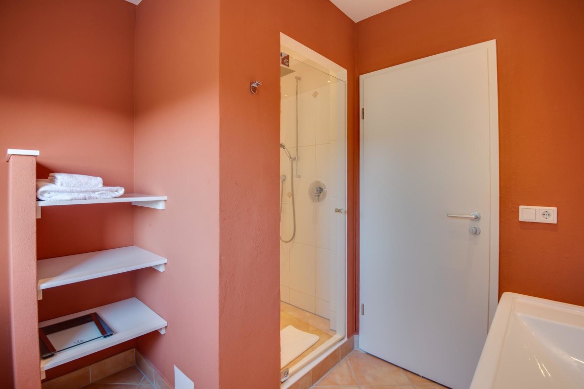 Gemütliches Badezimmer in Ferienwohnung "Perfall17", Schliersee. Helles Ambiente mit Dusche und Regalen. Ideal für Urlaub.