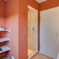 Gemütliches Badezimmer in Ferienwohnung "Perfall17", Schliersee. Helles Ambiente mit Dusche und Regalen. Ideal für Urlaub.