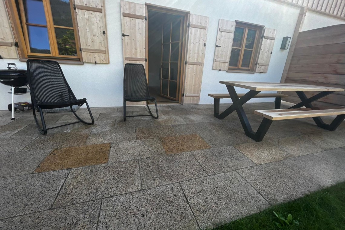 Gemütliche Terrasse einer Urlaubsunterkunft in Kreuth mit Sitzgelegenheiten und Grünfläche. Ideal für Erholung.