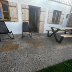 Gemütliche Terrasse einer Urlaubsunterkunft in Kreuth mit Sitzgelegenheiten und Grünfläche. Ideal für Erholung.