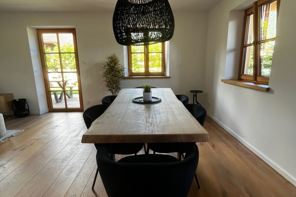 Gemütliches Esszimmer in einer Ferienwohnung in Kreuth mit Holztisch, moderner Beleuchtung und elegantem Interieur. #KreuthFerien