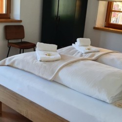 Gemütliches Schlafzimmer in Kreuther Ferienwohnung mit stilvoller Einrichtung und idyllischer Aussicht, ideal für Erholungssuchende.