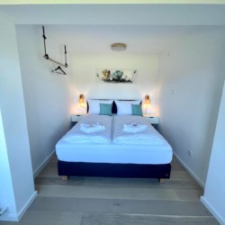 Helle FeWo in Bad Wiessee: Gemütliches Schlafzimmer mit Doppelbett & modernem Design, ideal für Bergurlaub. #BadWiessee #Ferienwohnung