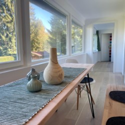 Helles Esszimmer in FeWo mit großem Fenster & Naturblick in Bad Wiessee. Gemütlich & stilvoll.