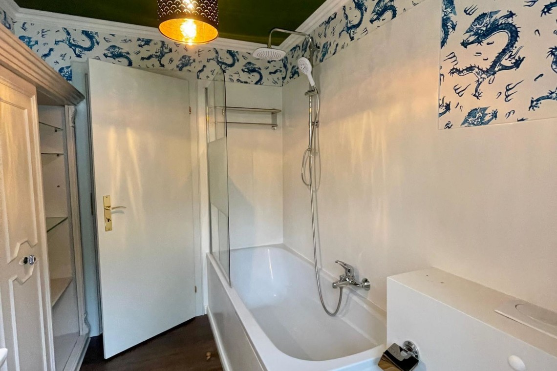 Moderne, stilvolle Ferienwohnung in Tegernsee: Bad mit Wanne, Einrichtung in Weiß, einladendes Design.