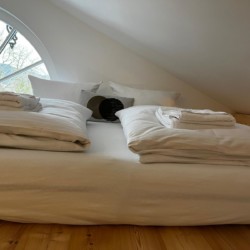 Gemütliches Dachgeschoss-Schlafzimmer mit natürlicher Beleuchtung in Gmund, ideal für Tegernsee-Urlaub.