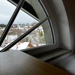 Gemütlicher Blick aus Apartmentfenster auf schneebedecktes Gmund am Tegernsee. Ideal für Urlaub und Entspannung.