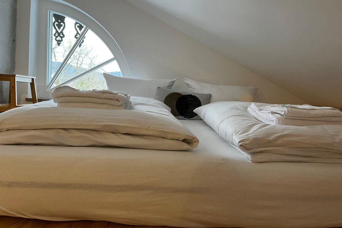 Gemütliches Dachgeschoss-Schlafzimmer, helle Einrichtung, in Gmund, nahe Tegernsee. Ideal für entspannten Urlaub.