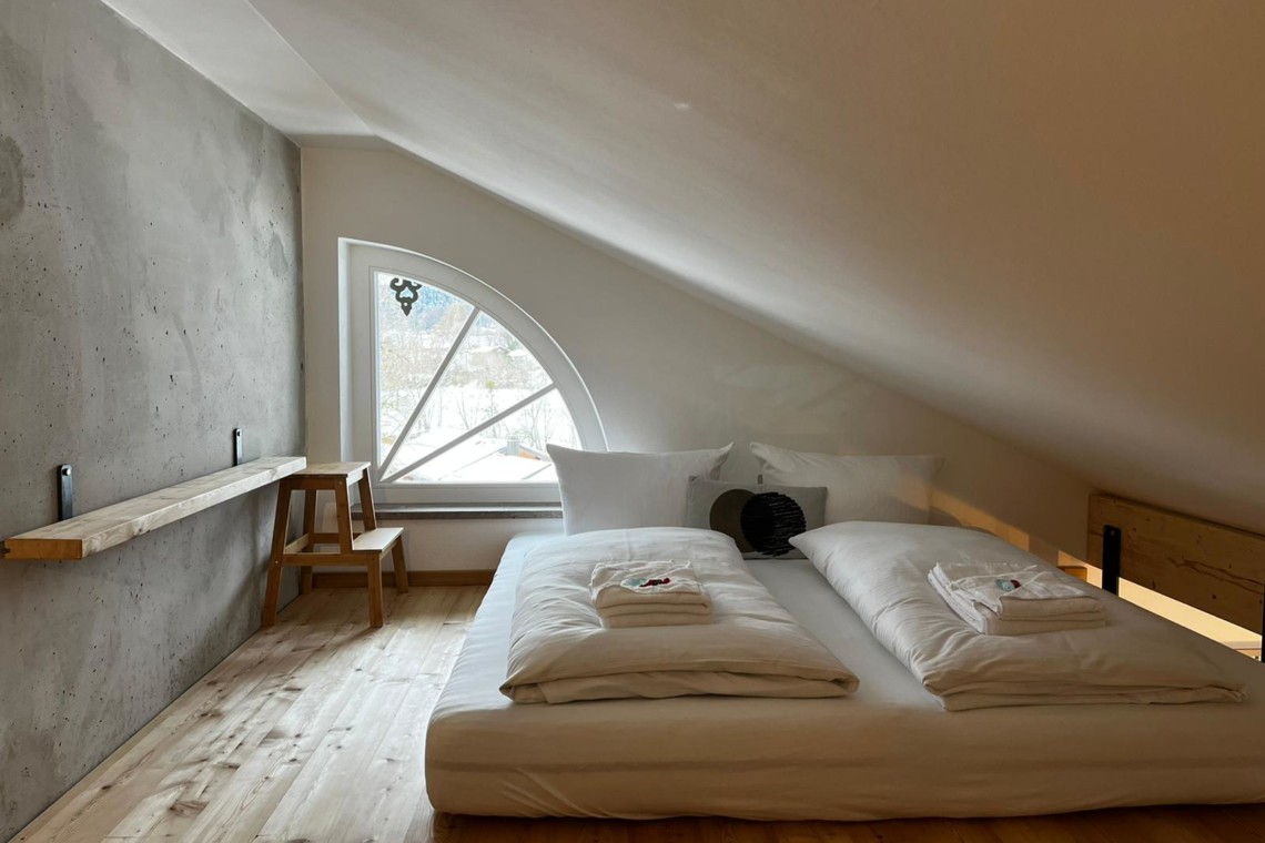 Gemütliches Schlafzimmer in Premium Ferienwohnung am Tegernsee, helle Einrichtung, für entspannten Urlaub.