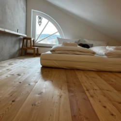 Helles, stilvolles Apartment am Tegernsee, gemütliches Schlafzimmer, Holzboden, mit Blick.