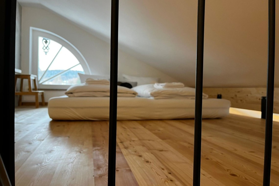 Stilvolle Ferienwohnung in Gmund am Tegernsee, holzgetäfeltes Schlafzimmer mit modernem Flair.