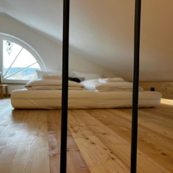 Stilvolle Ferienwohnung in Gmund am Tegernsee, holzgetäfeltes Schlafzimmer mit modernem Flair.