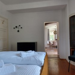 Gemütliches Schlafzimmer mit stilvoller Einrichtung und Blick ins Wohnzimmer, ideal für einen erholsamen Aufenthalt in Geitau.