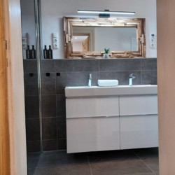 Moderne Ferienwohnung in Geitau, elegantes Badezimmer mit großem Spiegel und hellem Design. Ideal für entspannte Auszeit.