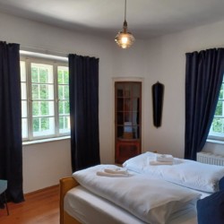 Gemütliches Schlafzimmer in der Ferienwohnung "Geitau59 III" mit Blick ins Grüne. Ideal für Entspannung in Geitau.