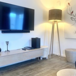 Gemütliches Wohnzimmer in Ferienwohnung Bergzauber in Schliersee mit TV und modernem Dekor.