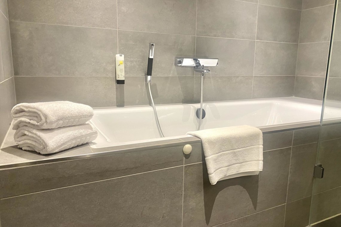Moderne Ferienwohnung in Schliersee mit elegantem Badezimmer, Wanne & frischen Handtüchern – ideal für Entspannung.