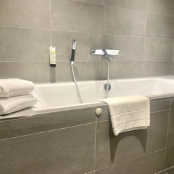 Moderne Ferienwohnung in Schliersee mit elegantem Badezimmer, Wanne & frischen Handtüchern – ideal für Entspannung.