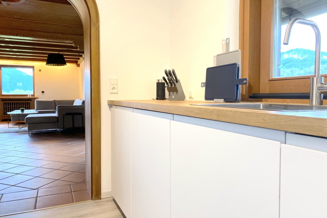 Modernes Premium Apartment in Bad Wiessee, elegantes Design, komfortable Küche, gemütliches Wohnzimmer mit Bergblick.